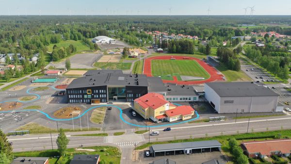 Koulurakennuksia ja taustalla urheilukenttä ja liikuntapaikkoja.
