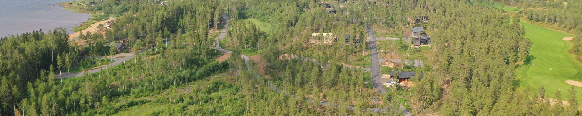 Meri ja metsää sen rannalla. Kuvassa myös tie ja golf-kenttä.