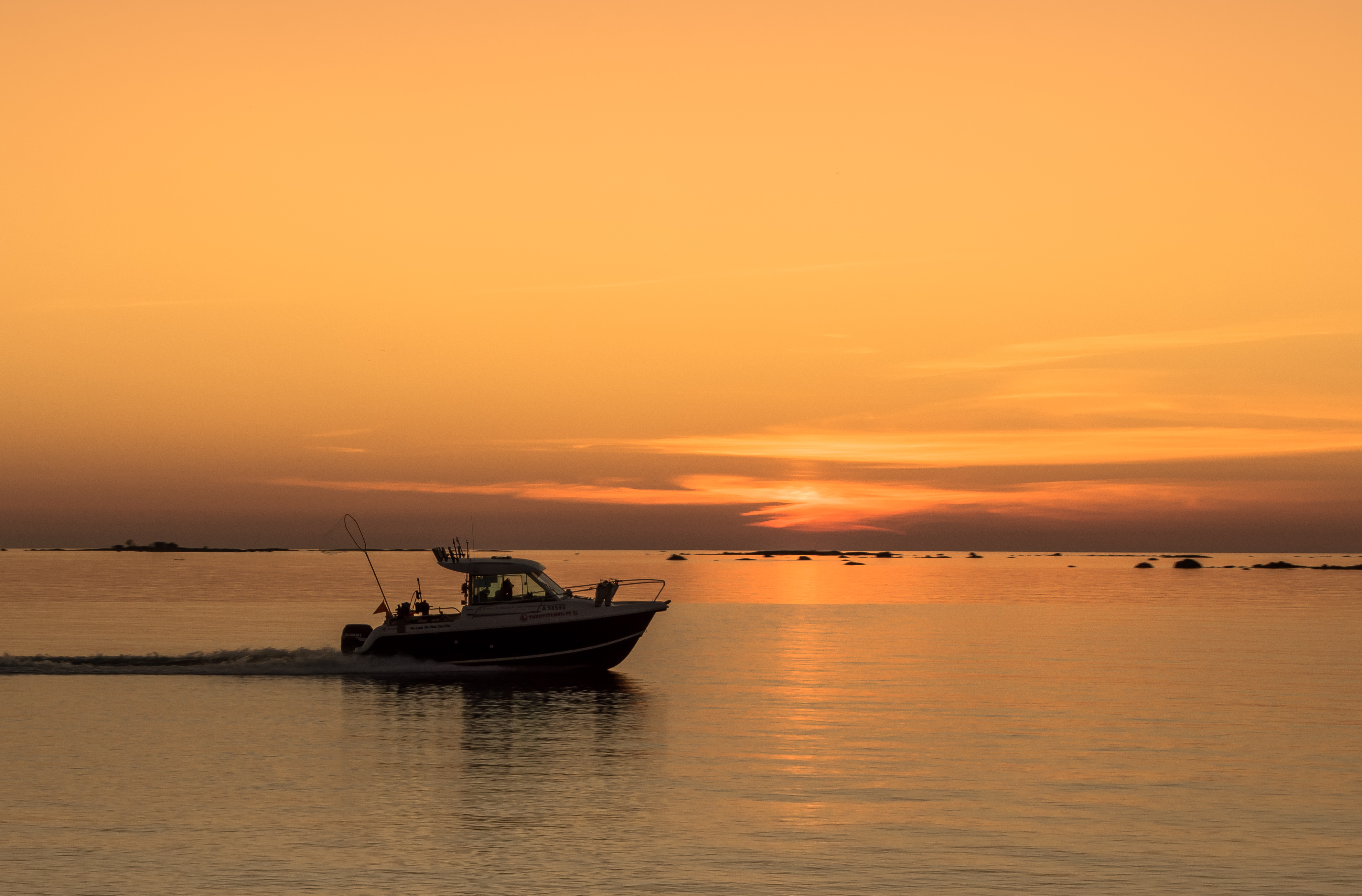 Kalastusvene merellä auringonlaskussa