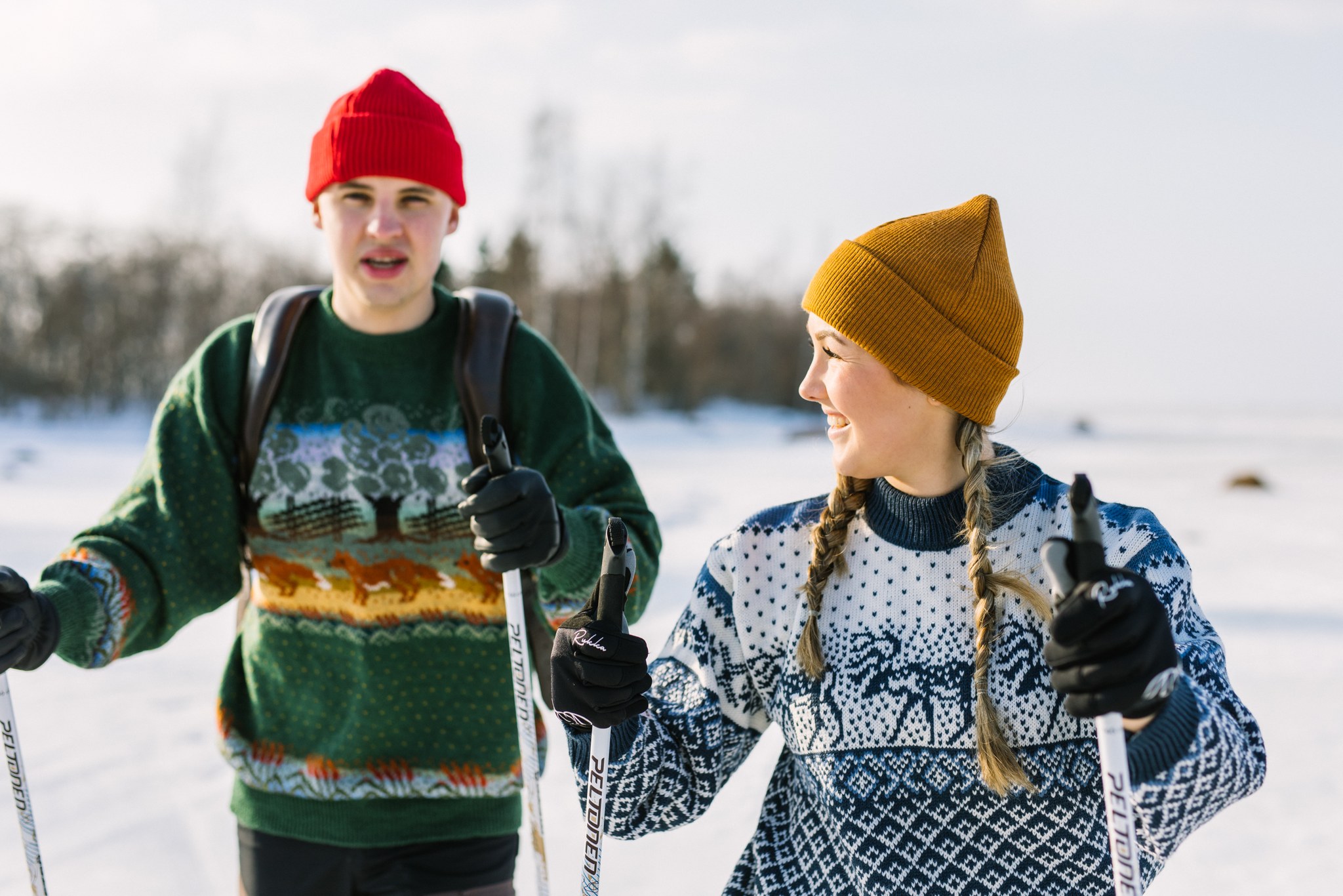 Nuori pariskunta hiihtämässä talvisäässä