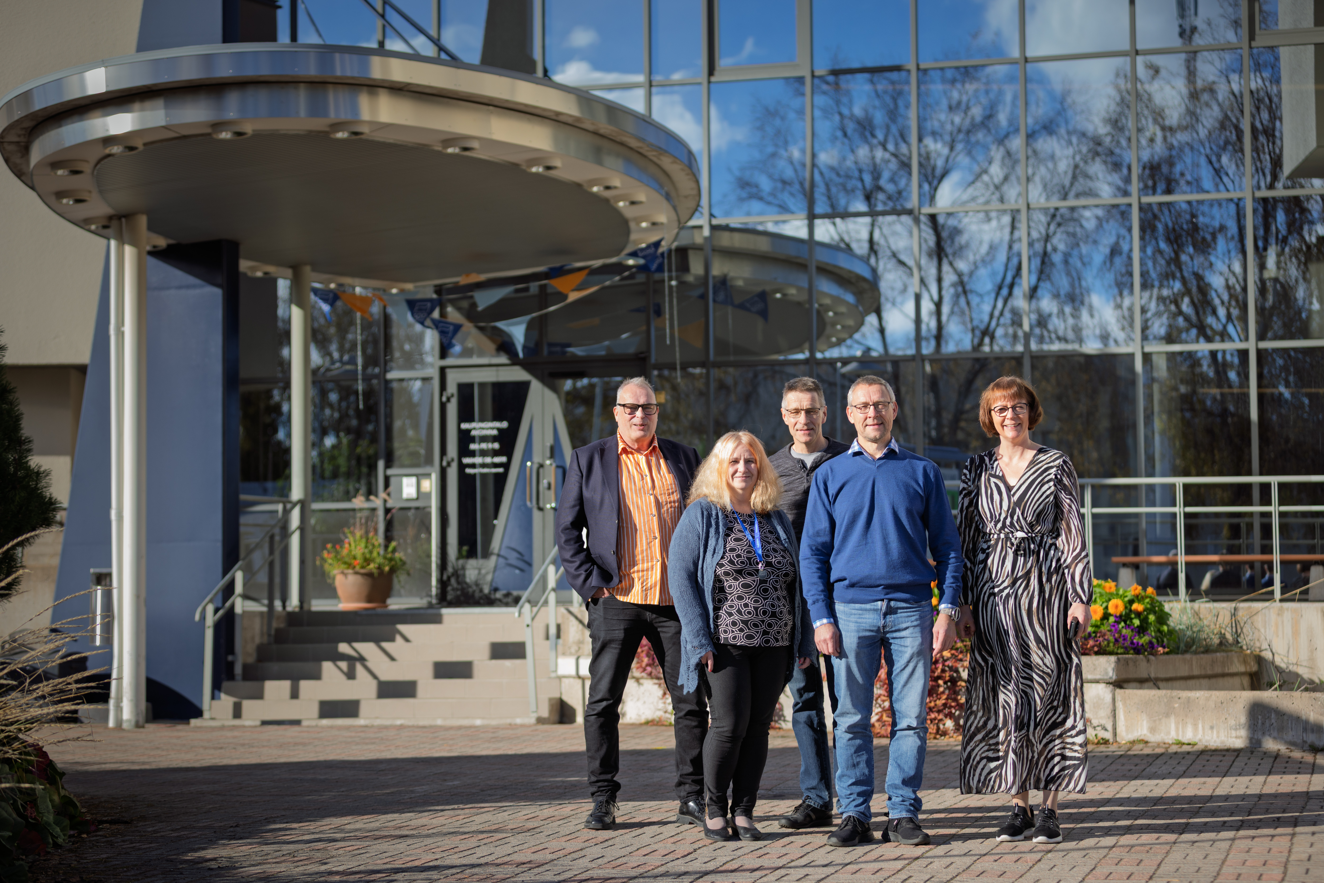 Viisi henkilöä seisoo Kalajoen kaupungintalon edustalla.