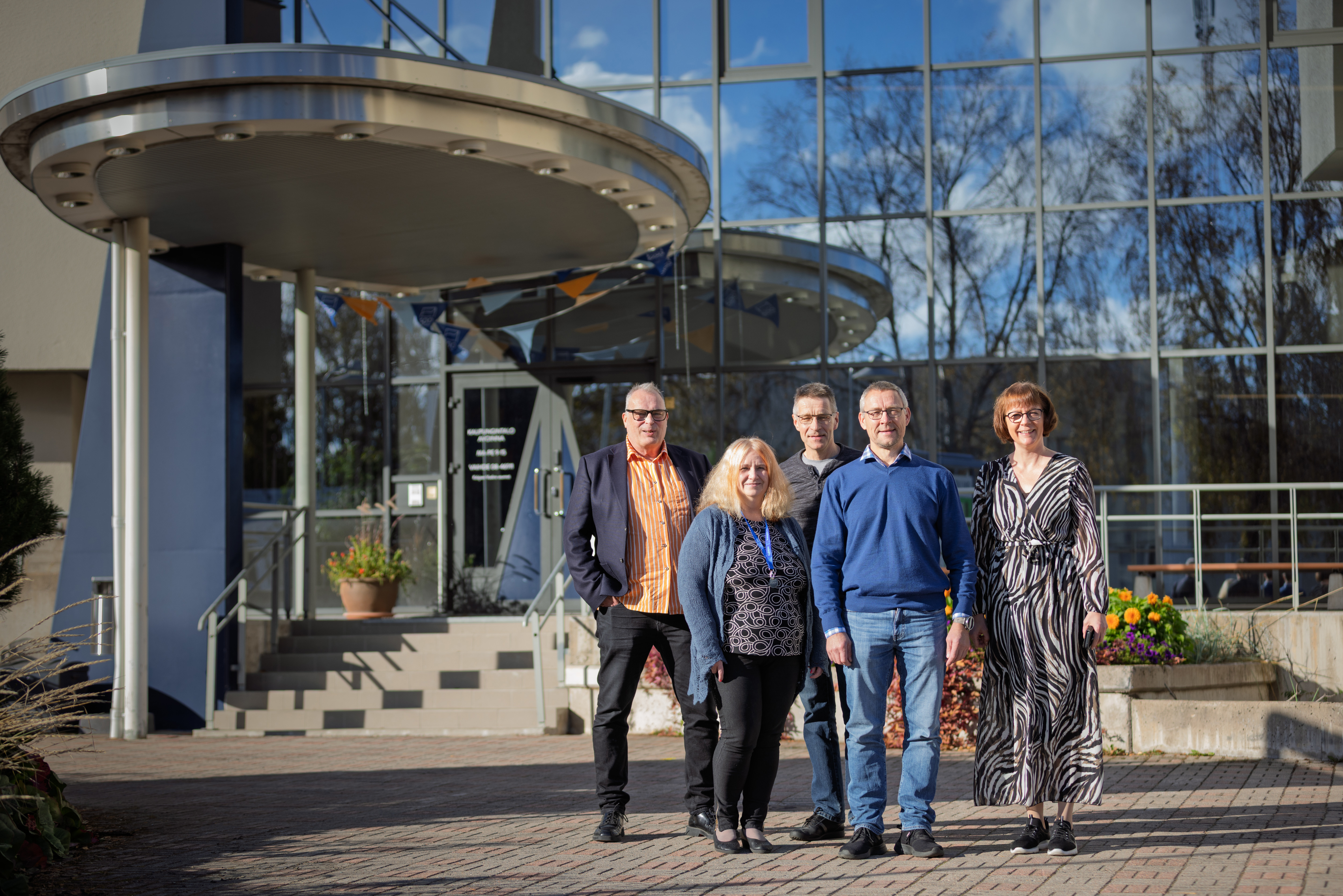 Viisi henkilöä seisoo Kalajoen kaupungintalon edustalla.