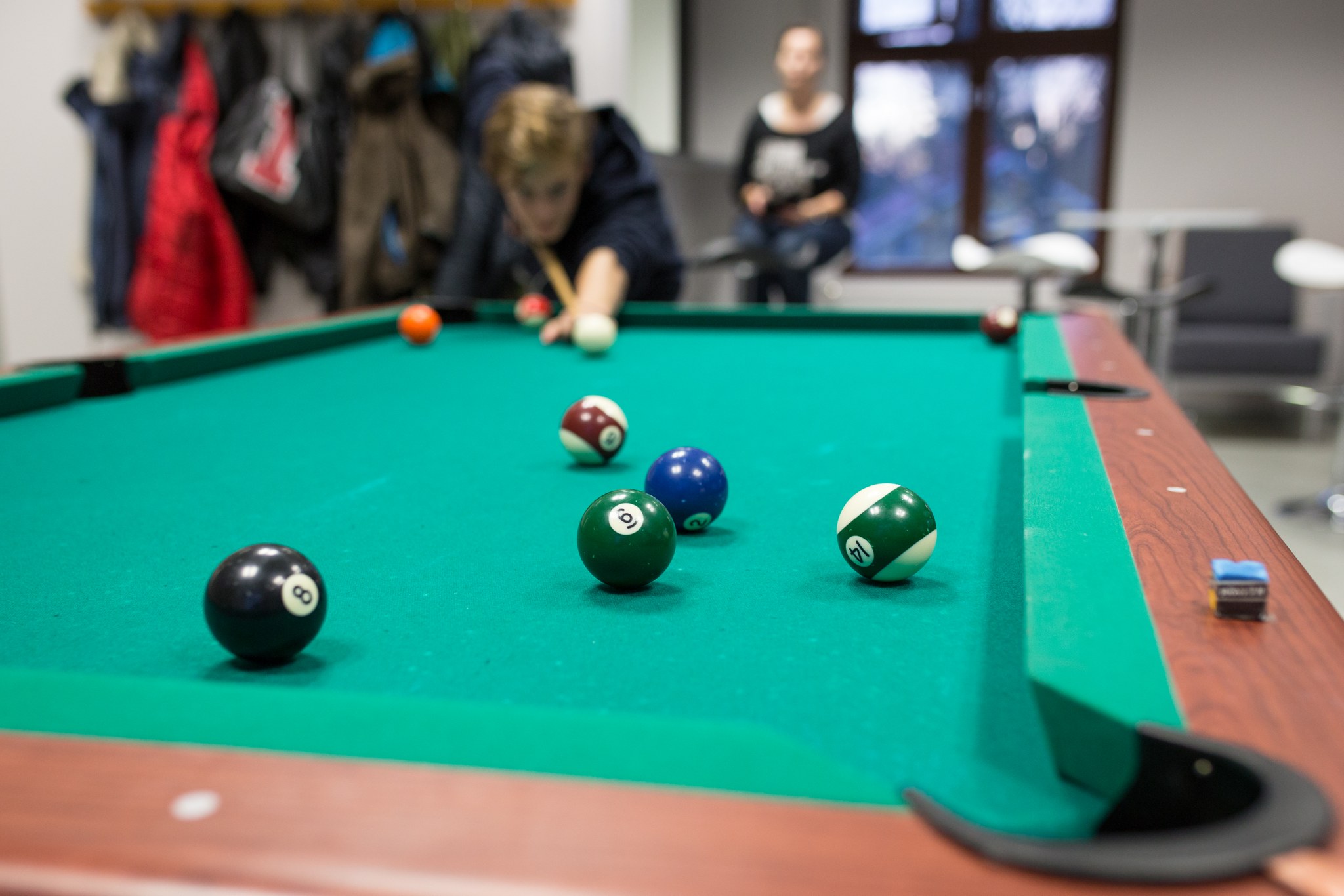 Henkilö pelaa biljardia.