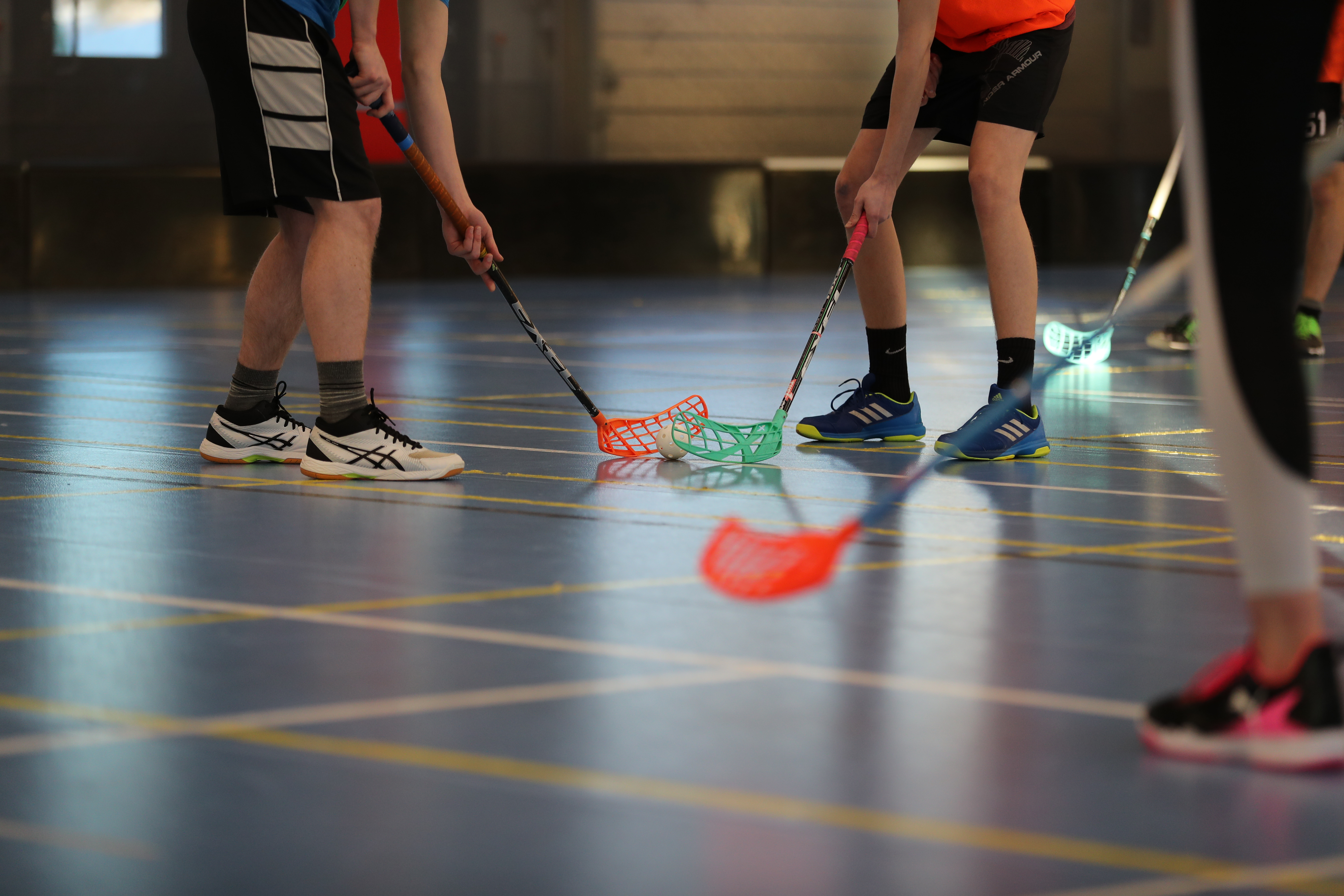 Salibandymailoja ja pelaajien jalkoja. 