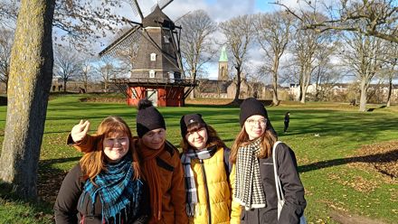 students in front of a wind mill