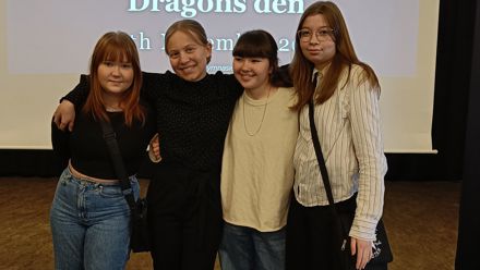 Students in front of a screen with the title of an event