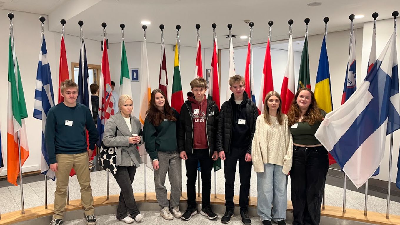 students in front of flags