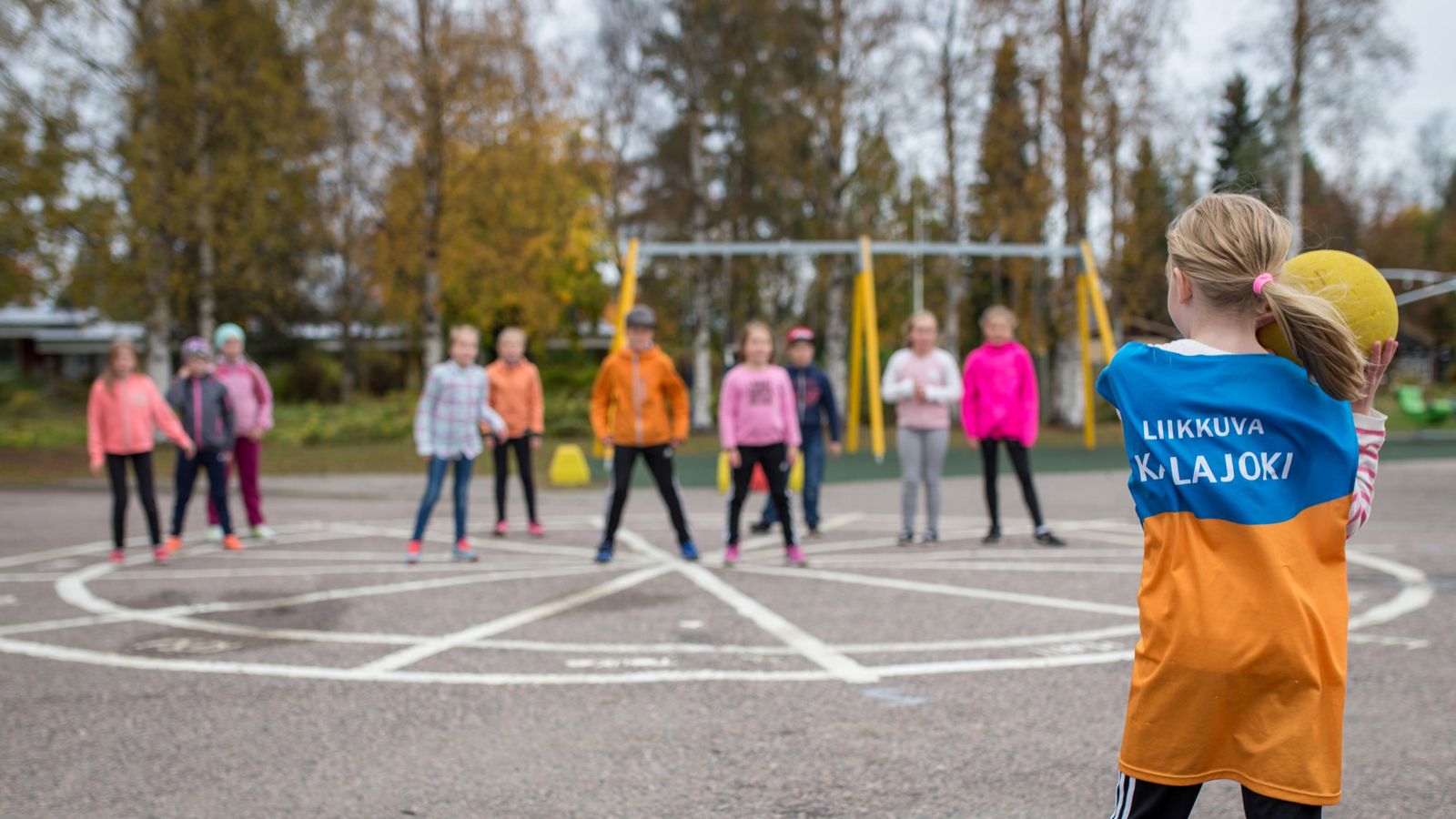 Päiväkoti- ja peruskouluikäisiä lapsia puistossa